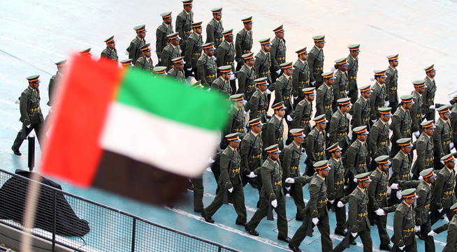 A spectator waves the Emirati flag as tr